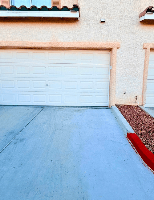 Closed white garage door with concrete driveway
